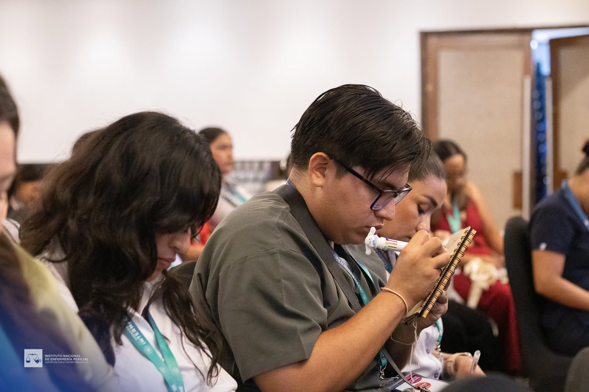 Profesional tomando notas durante una jornada académica